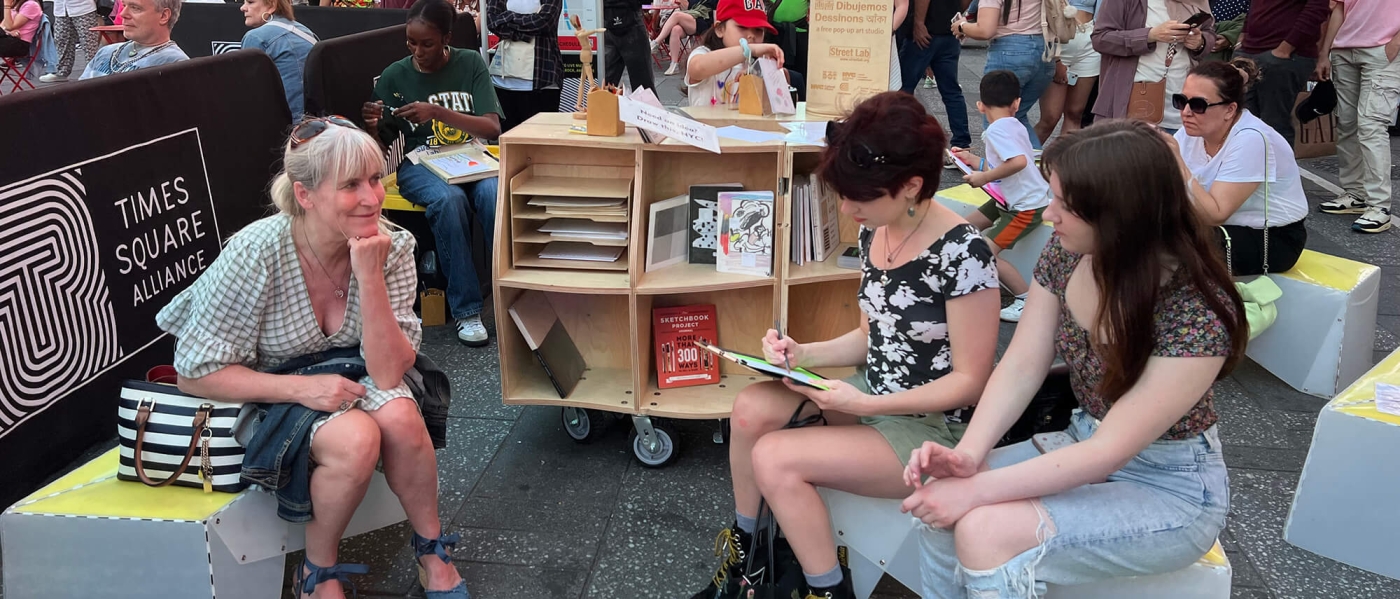 A group of people sitting and drawing at a Street Lab pop up in Times Square